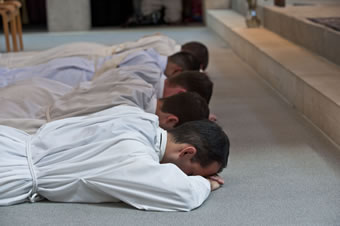 Five young monks prostrate before ordination.